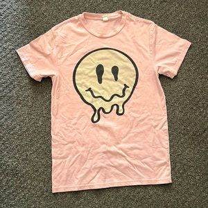 It’s a pink smiley face drip shirt from 5 below